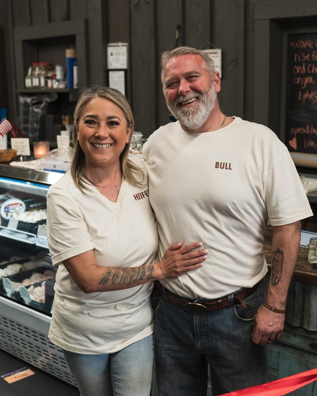 Ryan and Laura laughing together behind the counter at the shop